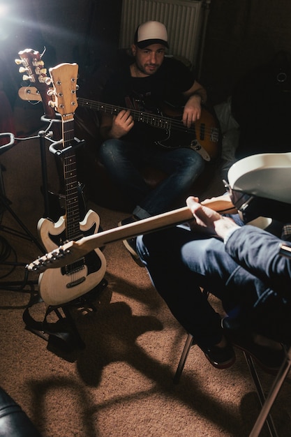 Guitarristas ensayando en estudio de música oscura