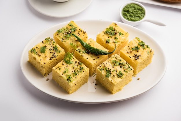 Gujarati Khaman Dhokla elaborado con Chana Dal, servido con chutney verde, enfoque selectivo