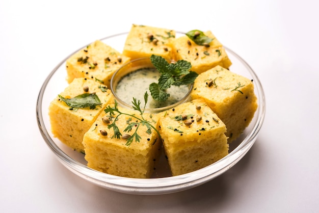 Gujarati Khaman Dhokla elaborado con Chana Dal, servido con chutney verde, enfoque selectivo