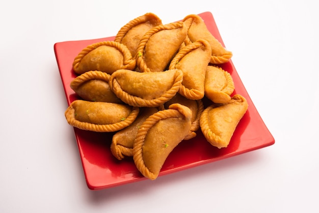 Gujiya oder Gujia oder Karanji. süße Teigtaschen, die während des Holi- und Diwali-Festes zubereitet werden, serviert auf einem Teller