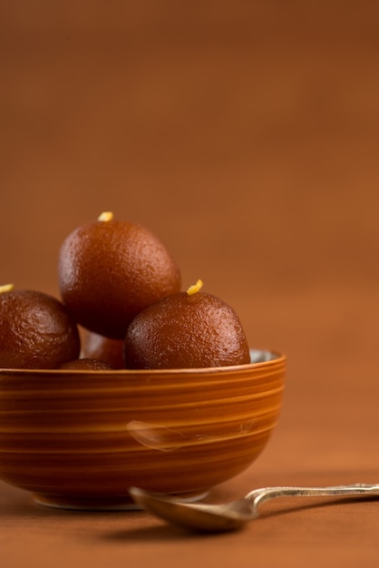 Gulab Jamun em tigela de madeira. Sobremesa Indiana ou Prato Doce.