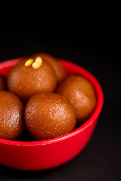 Gulab Jamun em tigela em preto. Sobremesa Indiana ou Prato Doce.