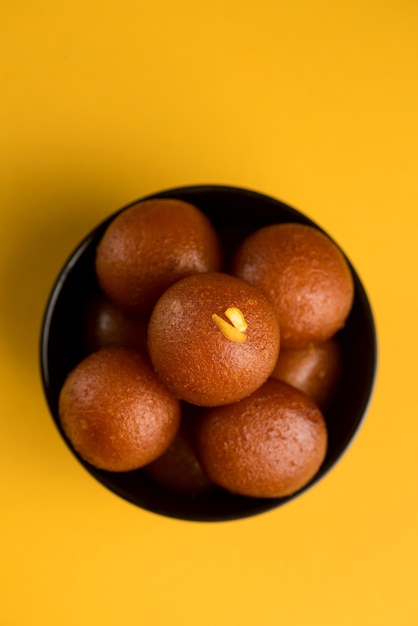 Gulab Jamun em uma tigela em amarelo.