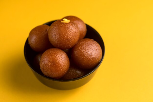 Gulab Jamun em uma tigela em amarelo.