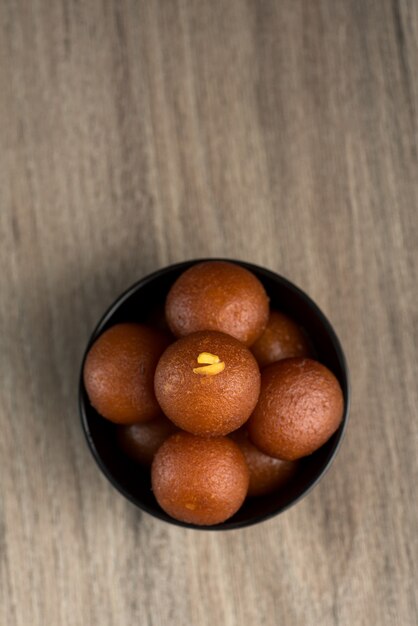 Gulab Jamun in der Schüssel auf hölzernem Hintergrund.