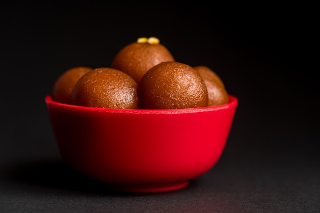 Gulab Jamun in Schüssel auf Schwarz. Indisches Dessert oder süßes Gericht.