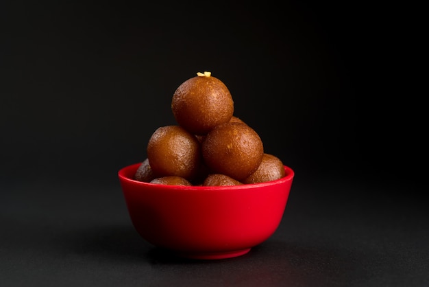 Gulab Jamun in Schüssel auf Schwarz. Indisches Dessert oder süßes Gericht.