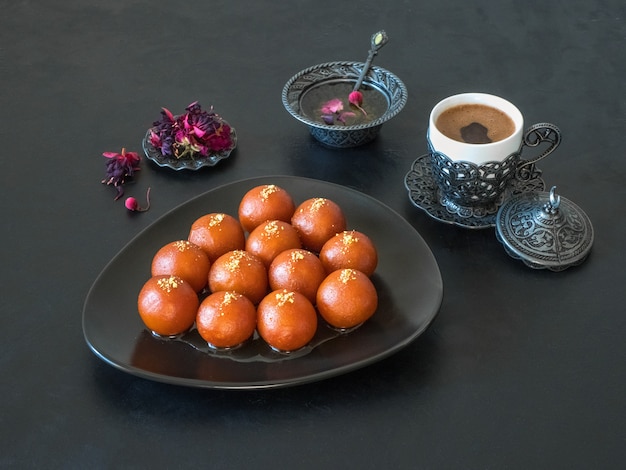 Gulab Jamun - Traditionelle indische Süßigkeiten auf einem schwarzen Tisch