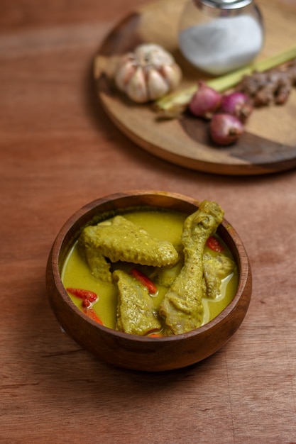 Gulai ayam um prato popular de curry de frango da indonésia servido em uma tigela de madeira