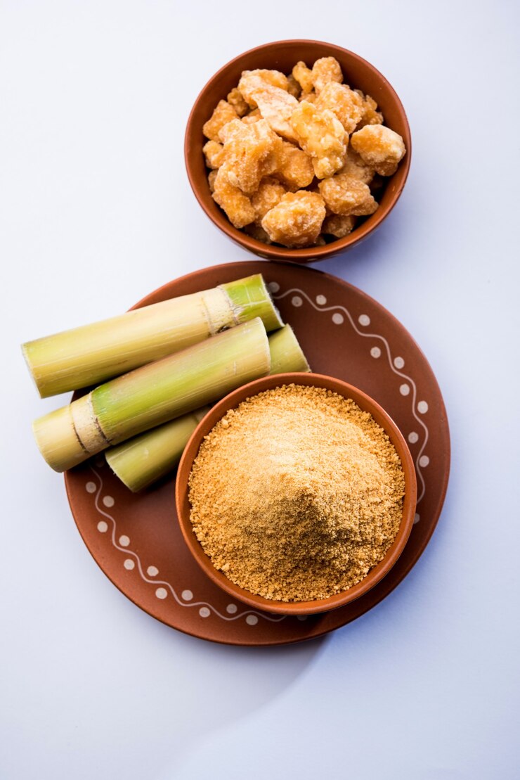 Foto gur orgânico ou jaggery em pó é o açúcar não refinado obtido do caldo concentrado da cana-de-açúcar. servido em uma tigela. foco seletivo