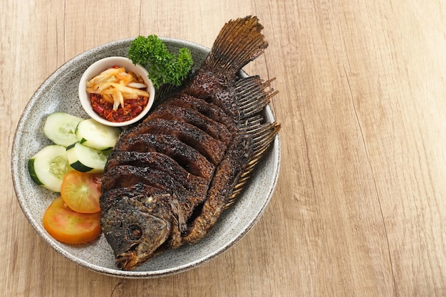 Gurame Bakar Madu, gegrillter Gourami mit Honig und Sojasauce. Serviert mit Sambal (Chilisauce).