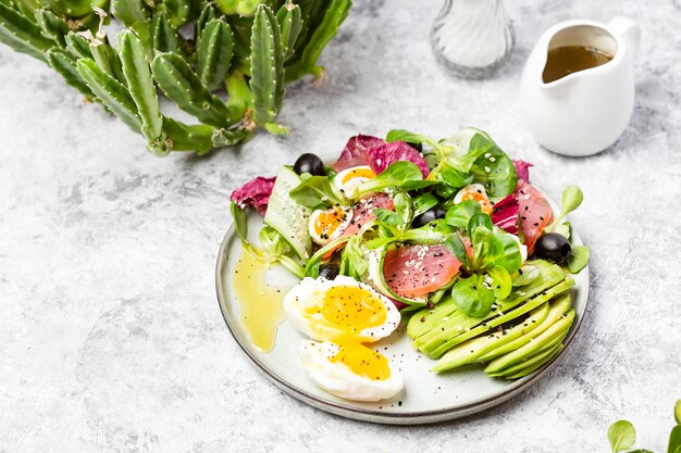 Gurken-, geräucherter Thunfisch- und Avocadosalat mit Ei und Oliven