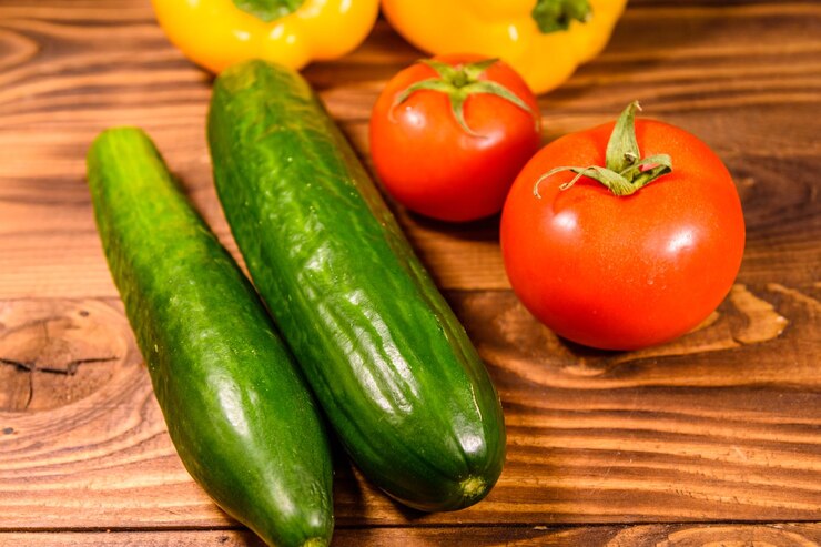 Foto gurken, tomaten und paprika auf holztisch