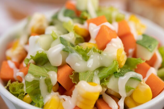 Gurkensalat, Mais, Karotte und Salat in einer weißen Tasse