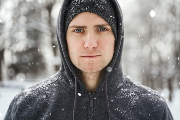 Gut aussehender athletischer Mann, der während seines Wintertrainings einen Hoodie trägt