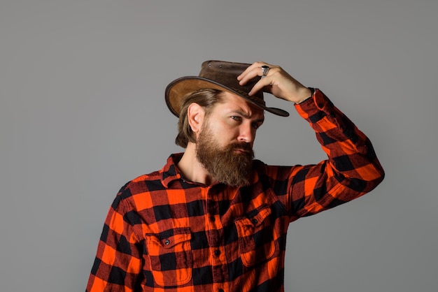 Gut aussehender bärtiger Mann im Cowboy-Stil mit Cowboyhut, sexy westlicher Mann mit Hut