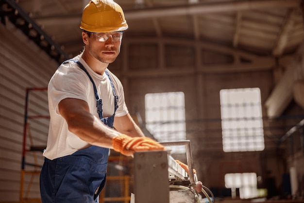 Foto gut aussehender baumeister mit holzbearbeitungsmaschine in der werkstatt