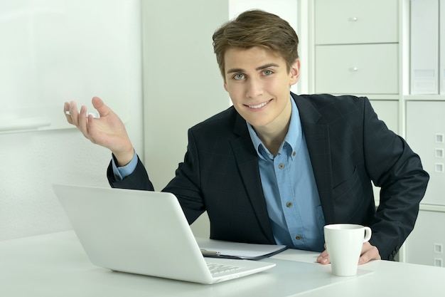 Gut aussehender Geschäftsmann, der mit Laptop im Büro arbeitet