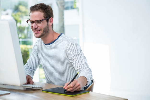 Gut aussehender Mann, der an Computer in einem hellen Büro arbeitet