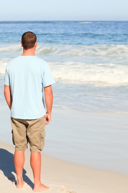 Gut aussehender Mann, der auf den Strand geht