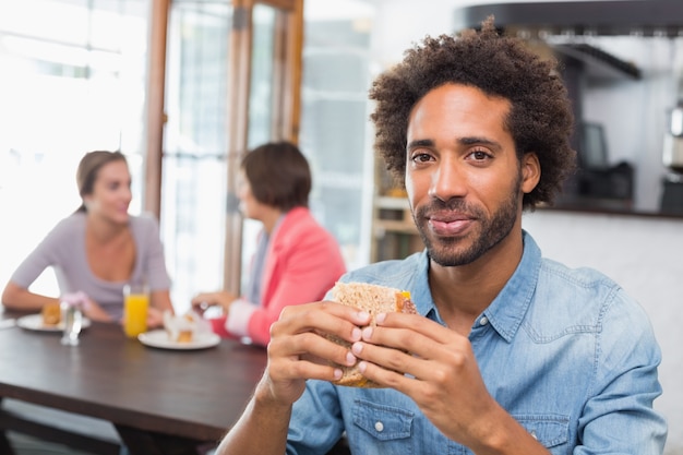 Gut aussehender Mann, der ein Sandwich isst