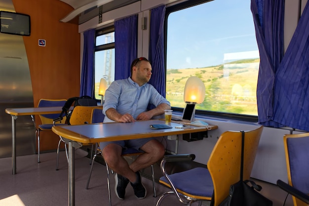 Gut aussehender Mann, der mit dem Zug reist und aus dem Fenster schaut Lizenzfreie Bilder