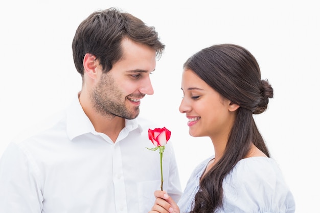 Gut aussehender Mann, der seiner Freundin eine Rose anbietet