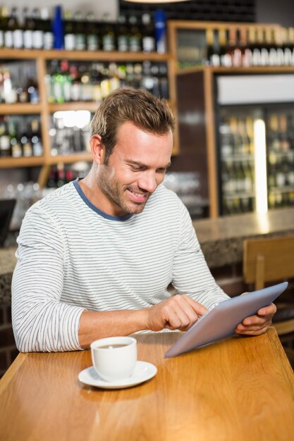 Gut aussehender Mann, der Tablet-Computer verwendet