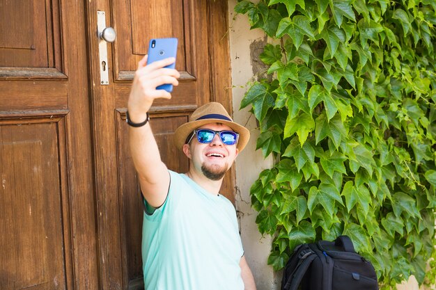 Gut aussehender Mann macht ein Selfie im Freien - Kaukasier - Natur, Menschen, Lifestyle und Technologiekonzept.