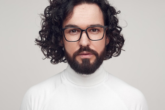 Gut aussehender Mann mit lockigem Haar und Brille