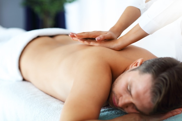 Gut aussehender Mann mit Massage im Spa-Salon