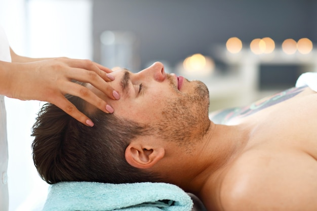 Gut aussehender Mann mit Massage im Spa-Salon