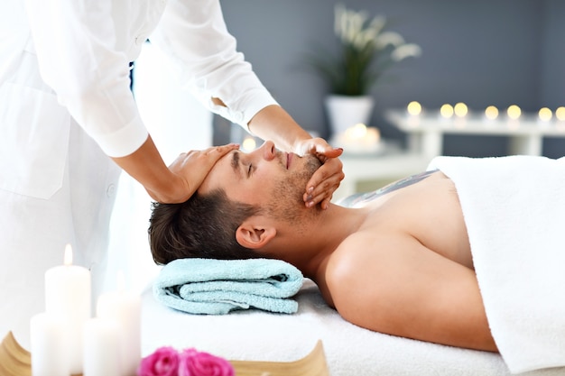 Gut aussehender Mann mit Massage im Spa-Salon