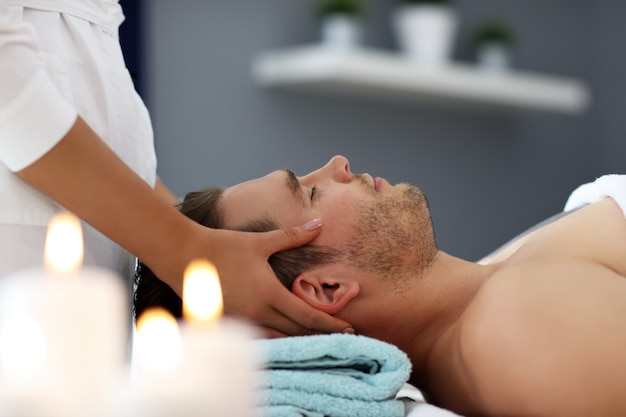 Gut aussehender Mann mit Massage im Spa-Salon