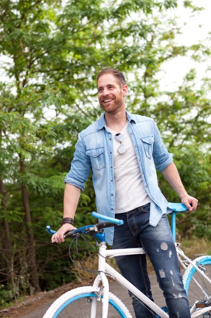 Gut aussehender Mann mit seinem Fahrrad im Park genießen