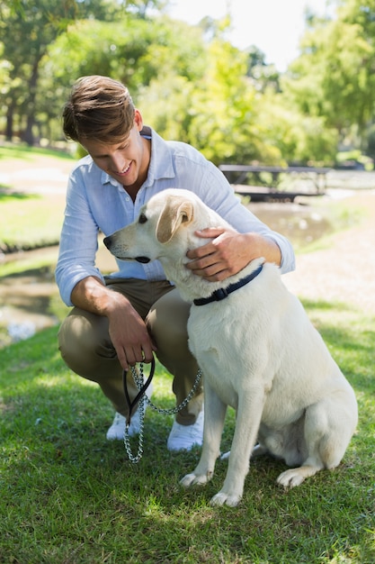 Gut aussehender Mann mit seinem Labrador im Park