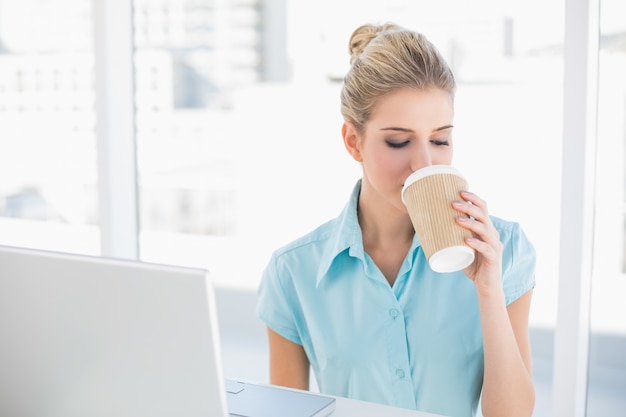 Gut gekleidete Geschäftsfrau, die Kaffee trinkt