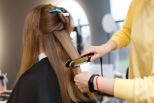 Foto gut gepflegtes haar glätten haare master hände im prozess der haarschnitte auf hintergrund