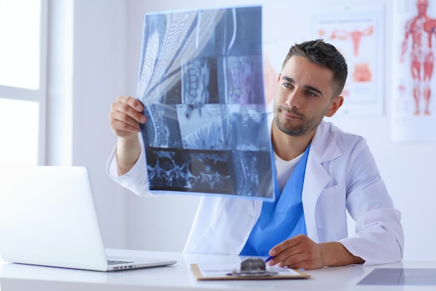 Gutaussehender Arzt spricht mit junger Patientin und macht