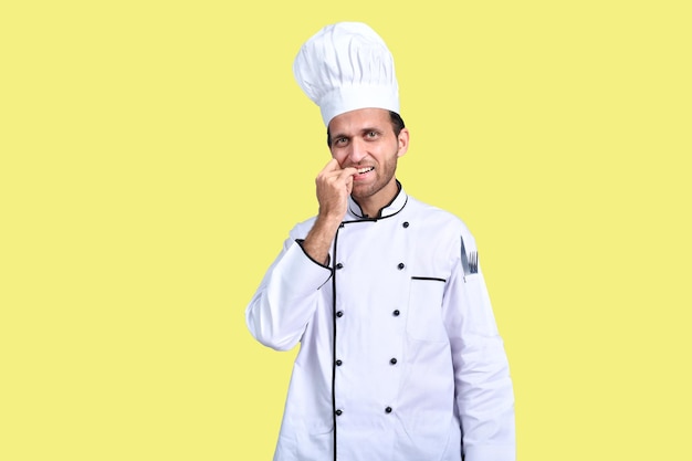 gutaussehender Koch Koch weißes Outfit über gelbem Hintergrund indisches pakistanisches Modell