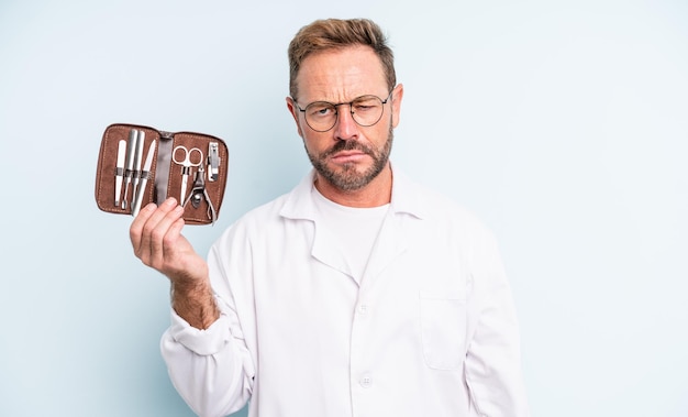 Foto gutaussehender mann mittleren alters, der sich traurig und weinerlich mit einem unglücklichen blick und weinen fühlt. podologe konzept