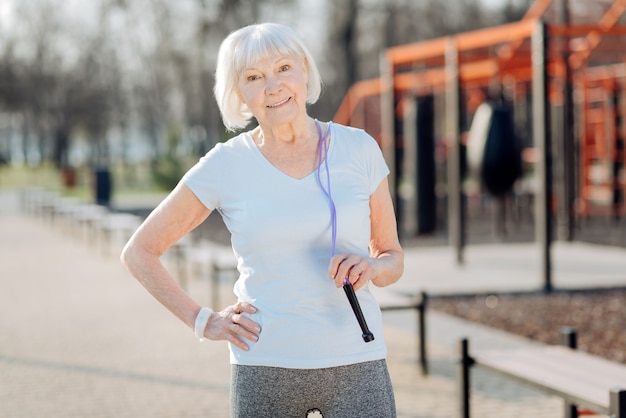 Gute Figur. Inspirierte dünne Frau, die sich beim Trainieren im Freien entspannt