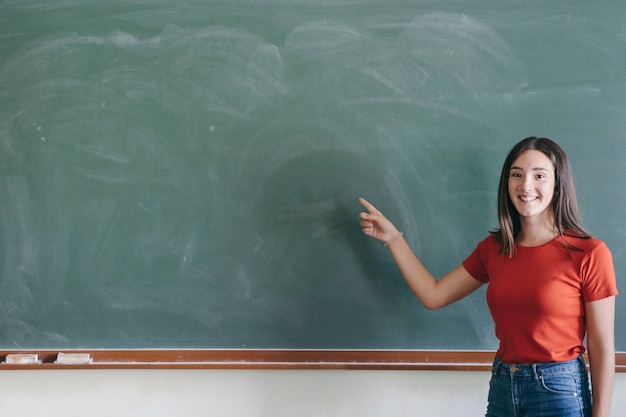 Gute Studentin, die auf das Blabkboard zeigt