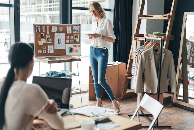 Guten Arbeitstag. Schöne junge Frau, die eine Geschäftsnachricht schreibt