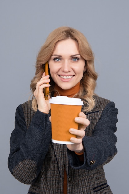 Guten Morgen. Glückliche Frau gibt Tasse am Telefon sprechen. Genießt ihren Morgenkaffee. Mobile Kommunikation. Moderne Technologie. Anruf tätigen.