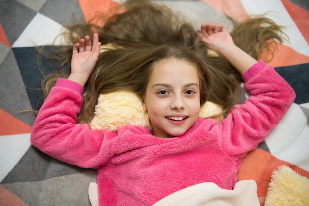 Guten Morgen. Ich will spielen. Internationaler Kindertag. Kindheitsglück. Kleines Mädchen, das bereit ist zu schlafen. Zeit zum Entspannen. Kleines glückliches Mädchen im Schlafzimmer. Pyjama Party. Gute Nacht.