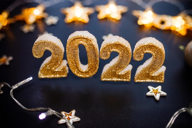 Guten Rutsch ins Neue Jahr 2022 Feiertagshintergrund mit goldenem Weihnachtsschmuck 2022 Zahlen mit Gold