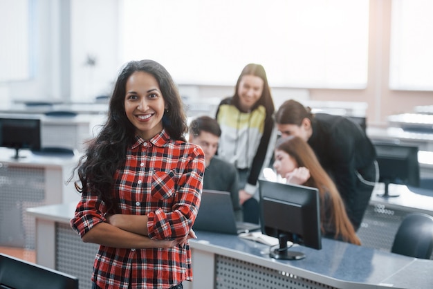 Guten und positiven Tag. Gruppe junger Leute in Freizeitkleidung, die im modernen Büro arbeiten.