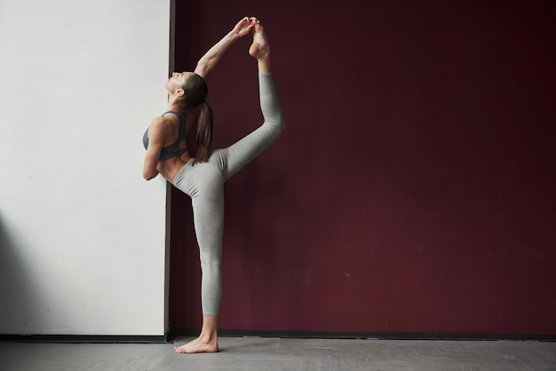 Gutes Dehnen. Mädchen mit guter Fitness Körpertyp haben Übungen im geräumigen Raum