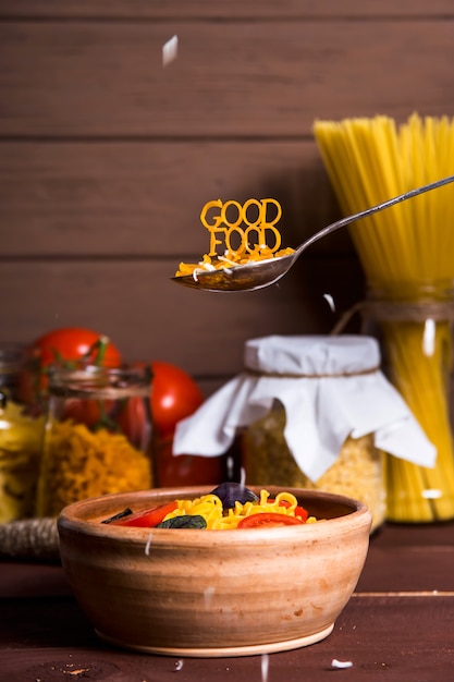 Gutes Essen wird mit Teigwaren auf einem Löffel neben einem Teller ausgekleidet